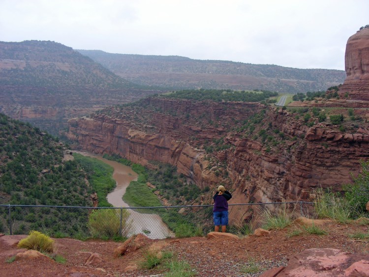 Norm viewing the hanging flume built in 1889 along the Dolores river canyon...